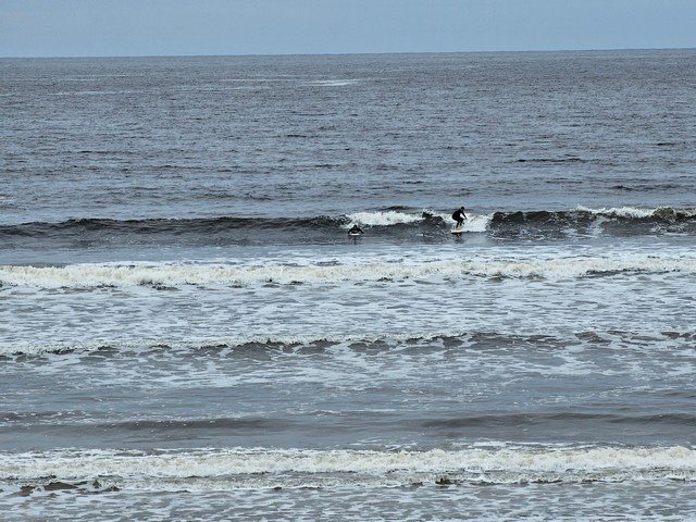 Surfer on a 2 foot wave directly in front of the shop
